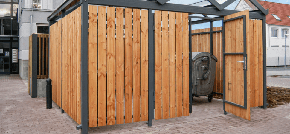 Overkapping voor opslag van goederen en afvalcontainers, van staal en hout in een woonwijk.
