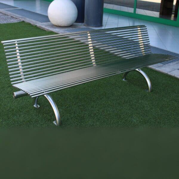 Buitenbank in RVS kopen voor openbare ruimte RVS buitenbank met rugleuning en gebogen poten geplaatst in een openbare ruimte.