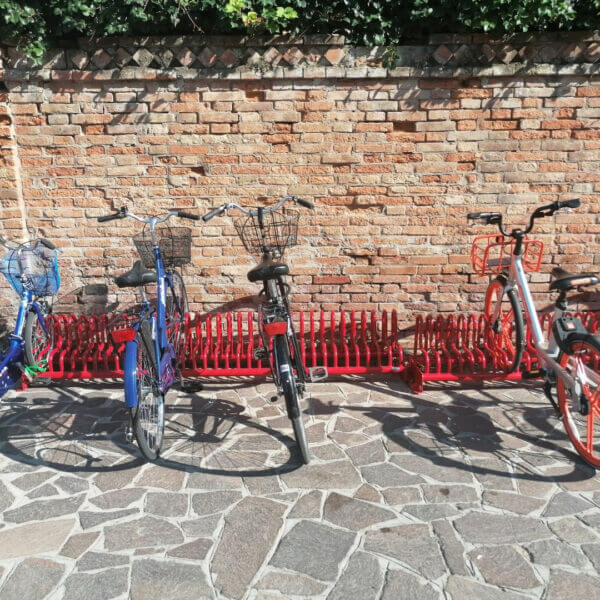 Fietsenrek Gamma in RAL-kleur naar keuze kopen Rood fietsenrek Gamma met geparkeerde fietsen tegen een bakstenen muur