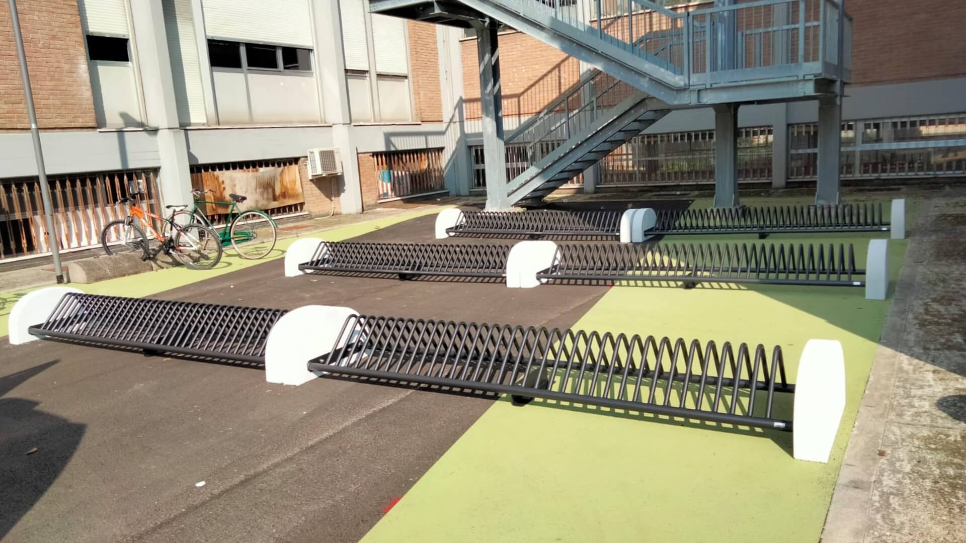 Meerdere fietsenrekken van staal en beton geplaatst op een binnenterrein voor het stallen van fietsen. 