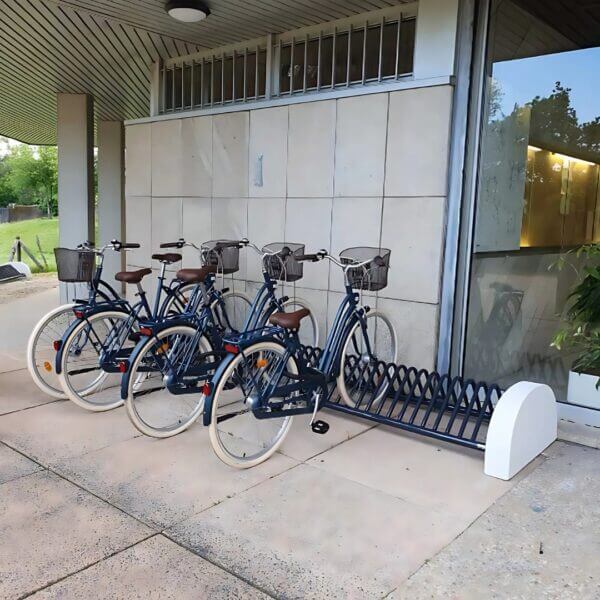 Fietsrek met betonvoet direct online bestellen Fietsrek met betonvoet en blauwe fietsen bij een entree van een gebouw