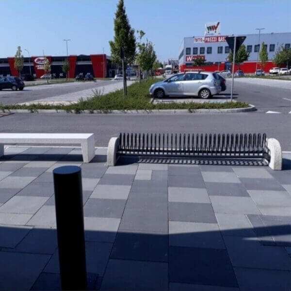 Fietsenrek met wielsteunen en beton voor parkeerplaatsen Fietsenrek met hoge wielbeugels en betonblokken op parkeerterrein