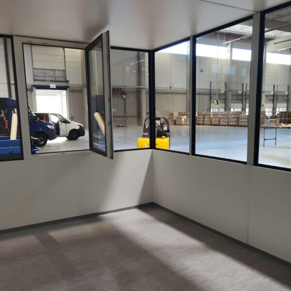 Kantoorunit 4x2m W Serie W12 Zonder Vloer Kopen Binnenkant van een kantoorunit met veel ramen, geplaatst in een bedrijfshal