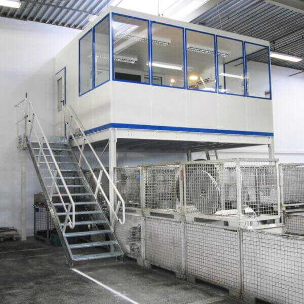Kantoorunit op bordes met trap Kantoorunit op bordes met trappen, ideaal voor werkruimtes in fabrieken en magazijnen.