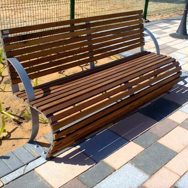 Houten parkbank 180 cm met stalen frame van Umfeldt Parkbank van hout met rugleuning en zilverkleurig stalen frame op betegeld terras.