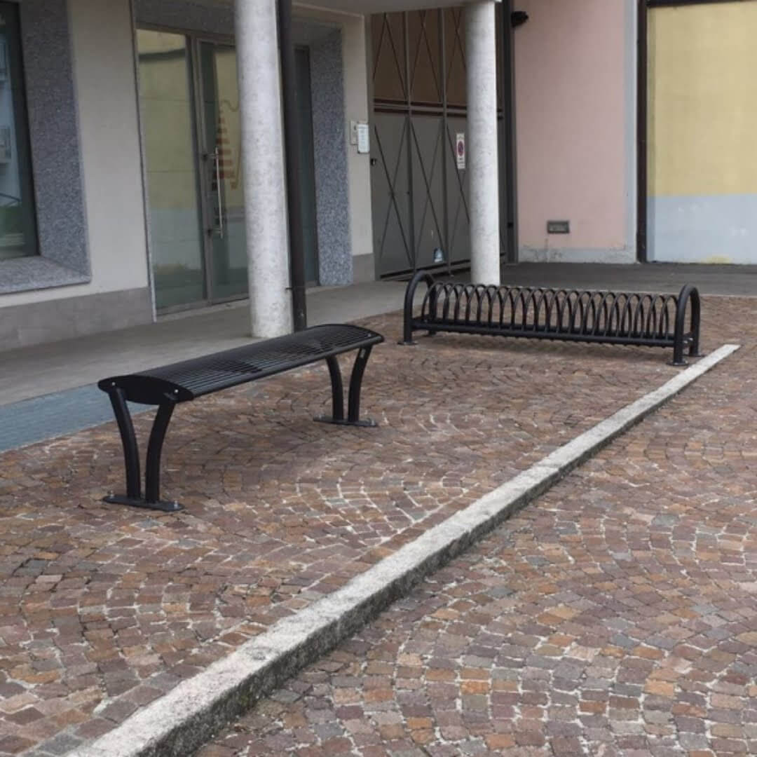 Stalen parkbank en fietsenrek geplaatst op een bedrijven terrein.