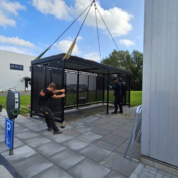 prefab-rijwieloverkapping-aanschaffen Prefab rijwieloverkapping met geperforeerde stalen wanden en sedumdak. Geplaatst bij Online Veilingmeester Groningen.