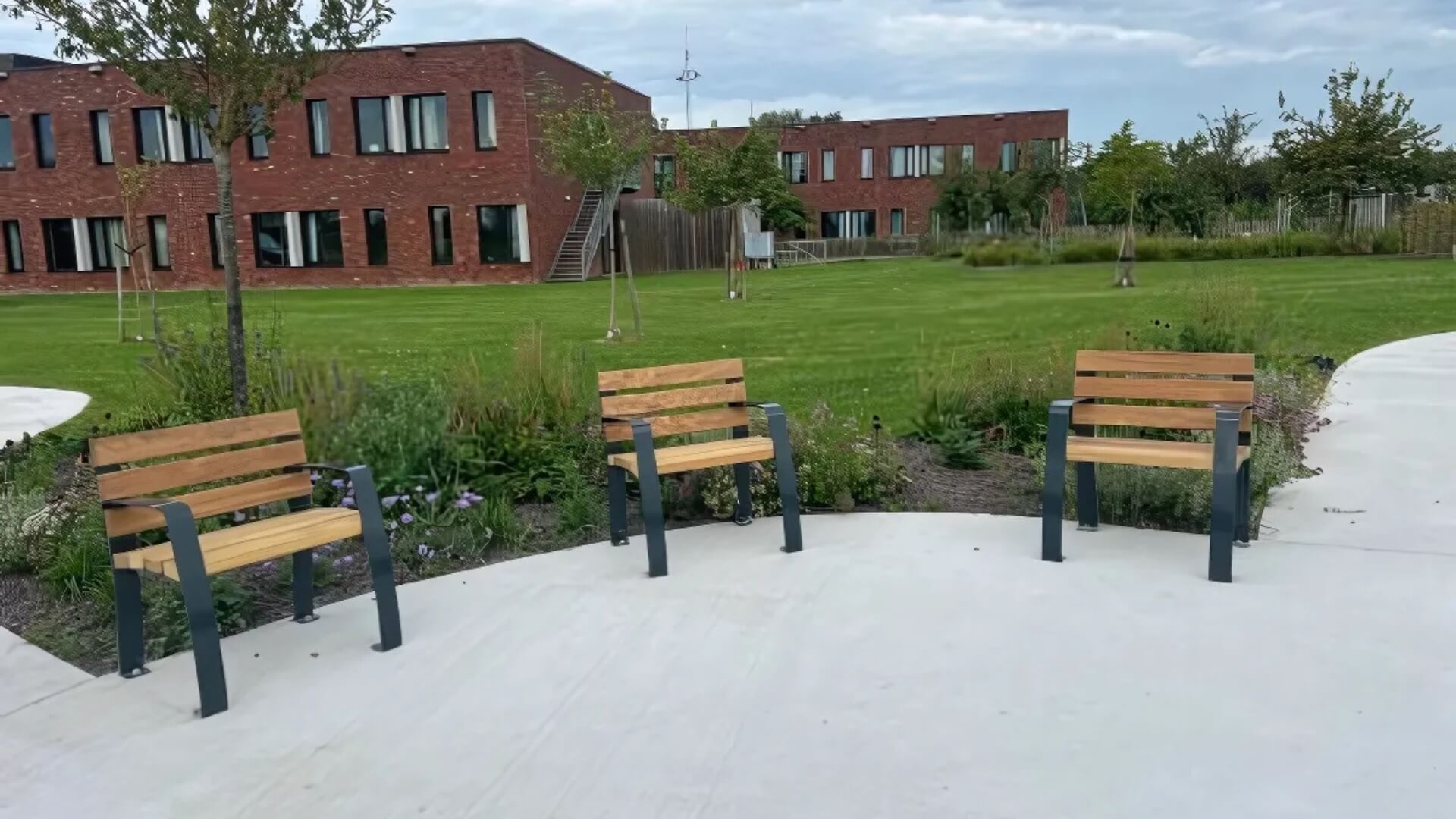 Parkstoelen met houten zitting en rugleuning in een groen hof