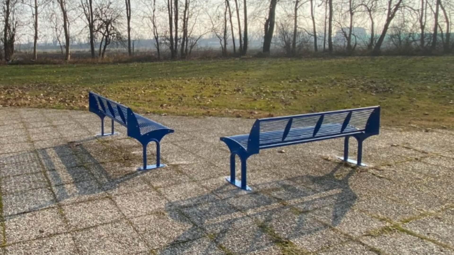 Blauwe stalen parkbanken op een plein in het park
