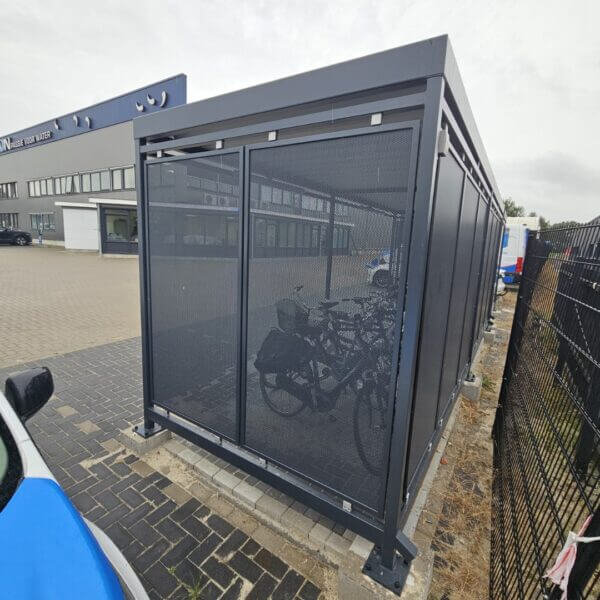 Fietsoverkapping met geperforeerde wanden direct bestellen Fietsoverkapping met geperforeerde staalplaatwanden en verzinkt stalen frame, geplaatst in Marum