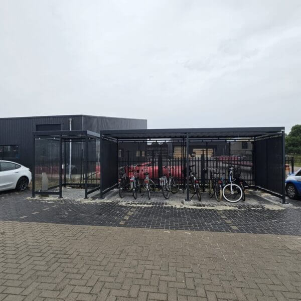 Combinatie rookruimte en fietsenstalling aanschaffen Rookabri en fietsoverkapping van verzinkt staal met geperforeerde wanden, geplaatst bij bedrijfspand in Marum