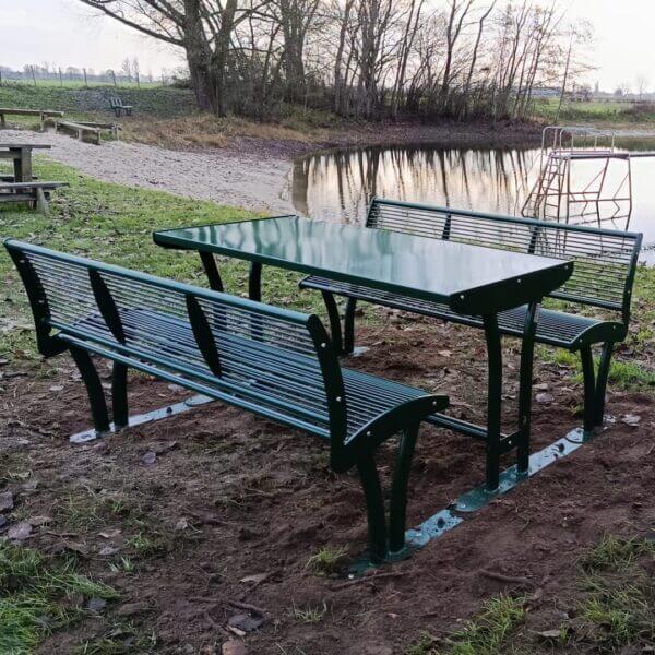 Picknicktafel met rugleuning direct voor parken kopen Mosgroene picknicktafel met rugleuningen in RAL 6005, geplaatst aan de waterkant in Wilp.