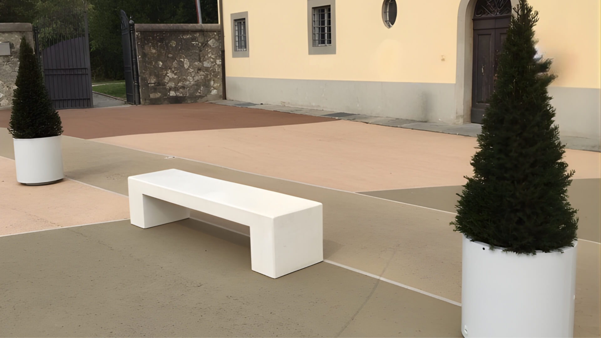 Plantenbank in cilindervorm geplaatst op openbare ruimte naast een gebouw